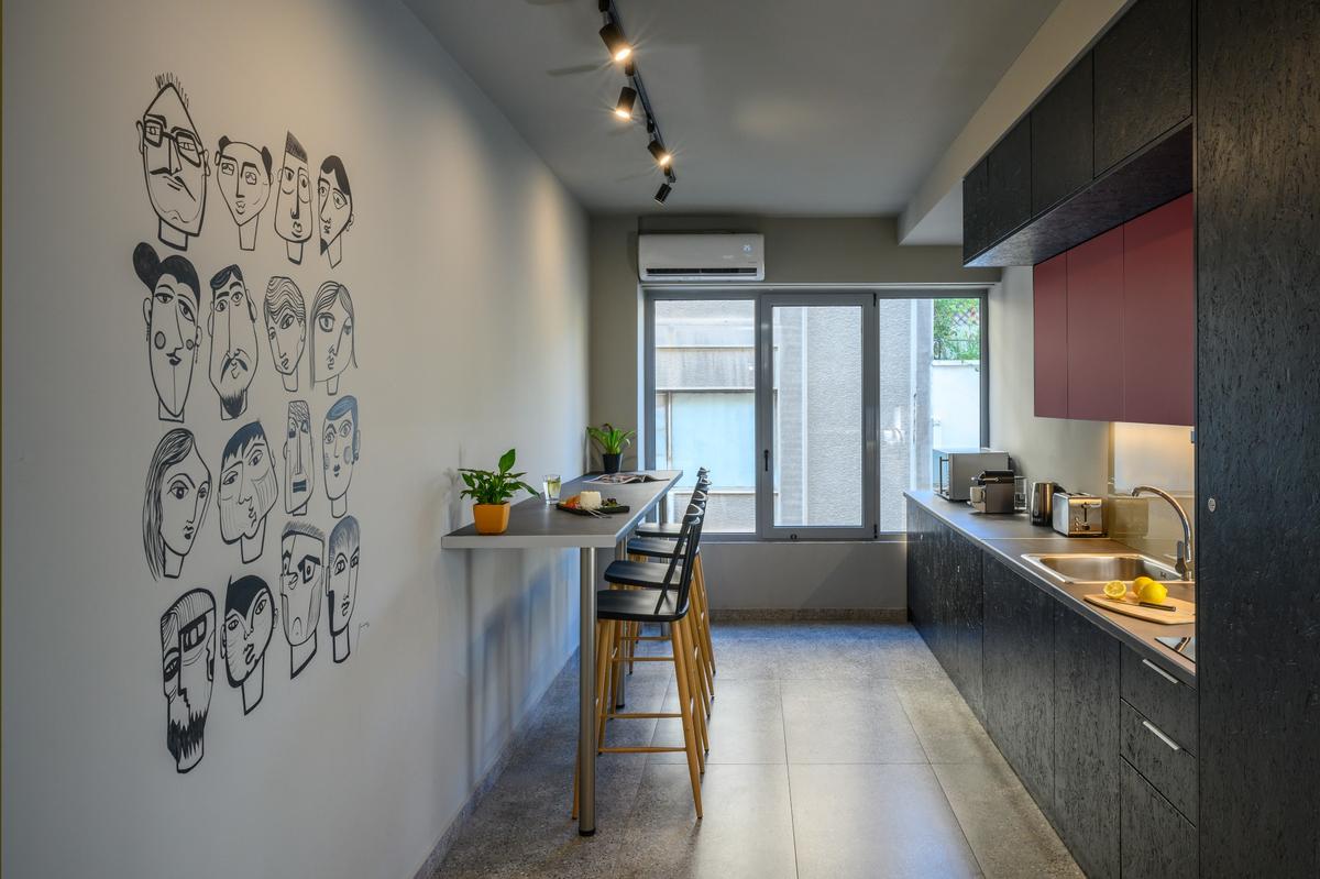 Shared kitchen at Psiri Vibes Hotel with modern decor and wall art.